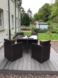 un patio con mesa y sillas en una terraza en Faskally Shores en Pitlochry