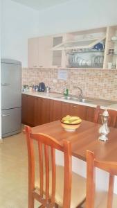 uma cozinha com uma mesa de madeira com um prato de bananas sobre ela em Sixth Apartment em Shkodër