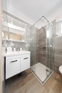 y baño con ducha acristalada y lavamanos. en Villa Silver en Starigrad-Paklenica