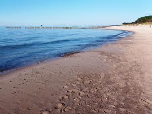 a beach with footprints in the sand and the ocean at Apartament "Rezydencja Park" w Mielnie in Mielno