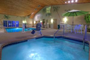 a indoor swimming pool with an umbrella and a swimming pool at Country Inn & Suites by Radisson, Waterloo, IA in Waterloo