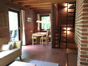 a living room with a table and a brick wall at 't Aarthuis in Emst
