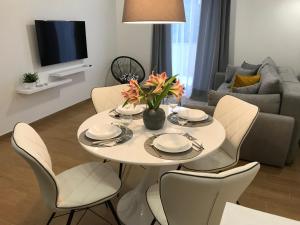 帕科坦FK Apartments的客厅里有一张白色的桌子和椅子