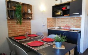 a kitchen with a table with red plates on it at Appartement Style Campagne - Vue montagne - Exposé plein Sud - Belle terrasse - in Font-Romeu