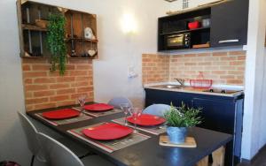 une cuisine avec une table et des plaques rouges. dans l'établissement Appartement Style Campagne - Vue montagne - Exposé plein Sud - Belle terrasse -, à Font-Romeu