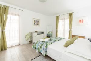 een witte slaapkamer met 2 bedden en ramen bij AMI 3 in Split