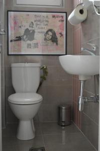 uma casa de banho com um WC, um lavatório e um cartaz em Mystic River Design Hostel em Bajina Bašta
