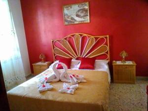 two swans are sitting on a bed in a bedroom at Le Stelle Del Tirreno in Falcone