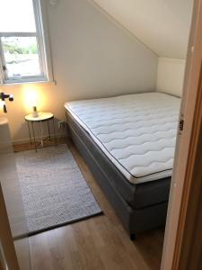 a small bedroom with a bed and a window at Ballstad Brygge Rorbu in Ballstad