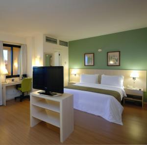 a bedroom with a large bed and a television at Rede Concept - Hotel Salvador in Salvador