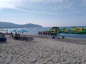 una playa con un grupo de personas y toboganes de agua en Le Stelle Del Tirreno, en Falcone