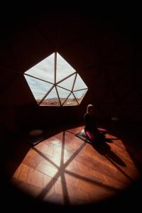 a person sitting on a floor in a room with a window at Santulan in Valle de Guadalupe