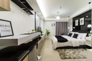 マニラにあるLuxury condo At Shore 1 Tower C1, Mall of Asia Complex Pasay Cityのベッドと机と洗面台のある寝室