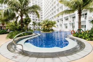 マニラにあるLuxury condo At Shore 1 Tower C1, Mall of Asia Complex Pasay Cityのヤシの木が茂る建物の中央にあるスイミングプール