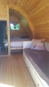 een kamer met 2 bedden in een houten hut bij POD des deux chênes in Louroux-Hodement