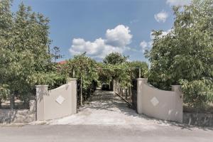 una entrada a una casa con una puerta y árboles en Villa Marilena with Jacuzzi en Pigadhákia