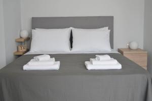 a bedroom with a bed with towels on it at MV House Agia Marina in Agia Marina Nea Kydonias