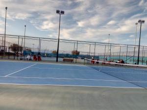 a tennis court with a net in front of the ocean at Cozy house 3 in Vrachati