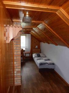 um quarto com uma cama num quarto com tectos em madeira em Chata v Moravském krasu em Sloup