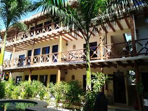 un edificio con una palmera delante de él en La Constanza de Rulo en Holbox Island