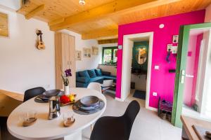 ein Wohnzimmer mit einem weißen Tisch und einer rosa Wand in der Unterkunft Pelagia House in Zlarin