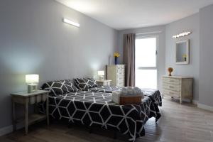 een slaapkamer met een bed met een zwart-wit dekbed bij Mesa del Mar Sunset Dream vacational rental home in Puerto de la Madera
