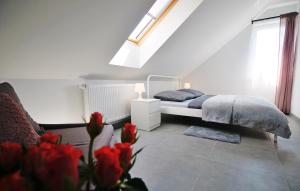 een slaapkamer met een bed met rode bloemen op de voorgrond bij Zatoka Wypoczynku Grzybowo - Apartamenty dwupoziomowe in Grzybowo