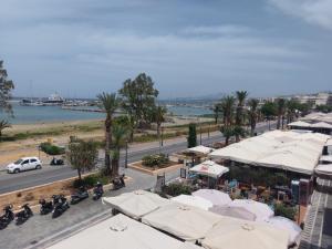 a view of a street with white umbrellas and a beach at Prokymaia Apartment 2 in Áyios Andónios
