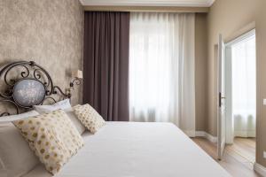 1 dormitorio con cama blanca y ventana en Elegant and cozy flat heart of Florence, en Florencia