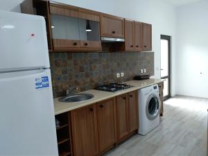 a kitchen with wooden cabinets and a washer and dryer at Casa Roka in Eşelniţa