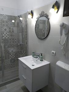 Un baño blanco con lavabo y ducha. en Casa Roka, en Eşelniţa