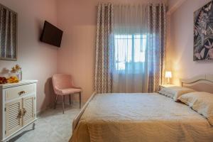 um quarto com uma cama, uma janela e uma cadeira em family house Nikos em Sikia