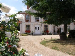 a large white house with flowers in front of it at Logis - Villa des Bordes in Cléry-Saint-André