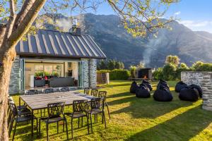 a backyard with a table and chairs and a grill at Gucci House in Queenstown