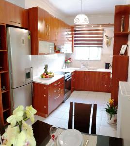 a kitchen with wooden cabinets and a stainless steel refrigerator at Petros Garden Ηouse in Gaïtánion