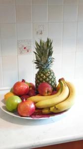 a plate of fruit on a counter with a pineapple and apples at Petros Garden Ηouse in Gaïtánion