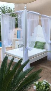 a white bed with curtains on a patio at Can Content - Playa de Muro in Muro