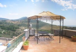 een patio met een tafel en stoelen onder een parasol bij Villa San Filippo in Cori