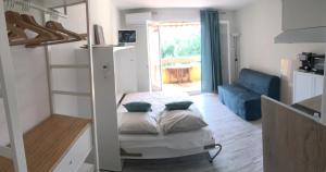 a small room with a bed and a living room at Studio rénové balcon ensoleillé et calme in La Londe-les-Maures