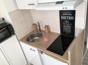 a kitchen with a sink and a book on a counter at Studio rénové balcon ensoleillé et calme in La Londe-les-Maures