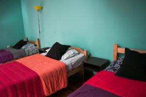 Habitación con 2 camas y mantas rojas. en Hostal Tricontinental, en Valparaíso