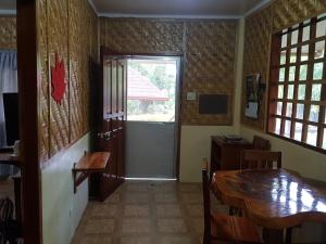 uma sala de jantar com uma mesa e uma janela em Mountain View Cottages em Mambajao