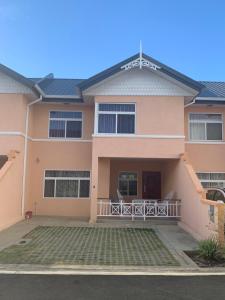 a large pink house with a balcony at Nzingha's Villa in Buccoo