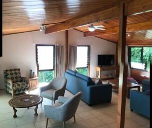 sala de estar con sofá azul y sillas en Pacific views, tranquil location, extra large home, Navy House 1 en Rarotonga