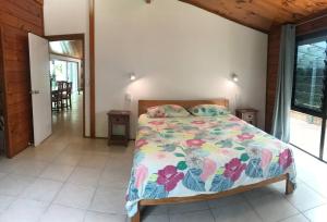 a bedroom with a bed with a colorful comforter at Pacific views, tranquil location, extra large home, Navy House 1 in Rarotonga