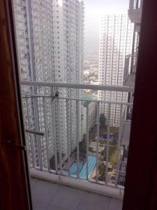 馬尼拉的住宿－貝殼公寓，享有游泳池和建筑景致的阳台
