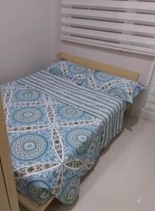 馬尼拉的住宿－貝殼公寓，床上有蓝色和白色的被子