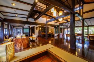 a large living room with wooden floors and ceilings at Shirakabeso in Izu