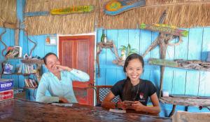 Un uomo e una donna seduti a un tavolo di Firefly Guesthouse a Koh Rong Island