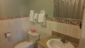 a bathroom with a toilet, sink, and mirror at Riviera Motel in Anaheim